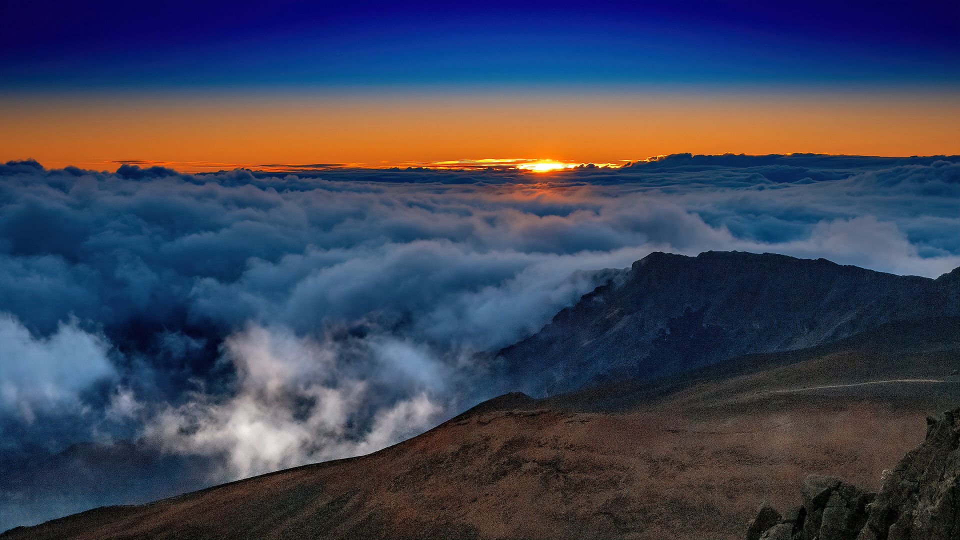 Sunrise above a sea of clouds at Haleakalā, Maui
