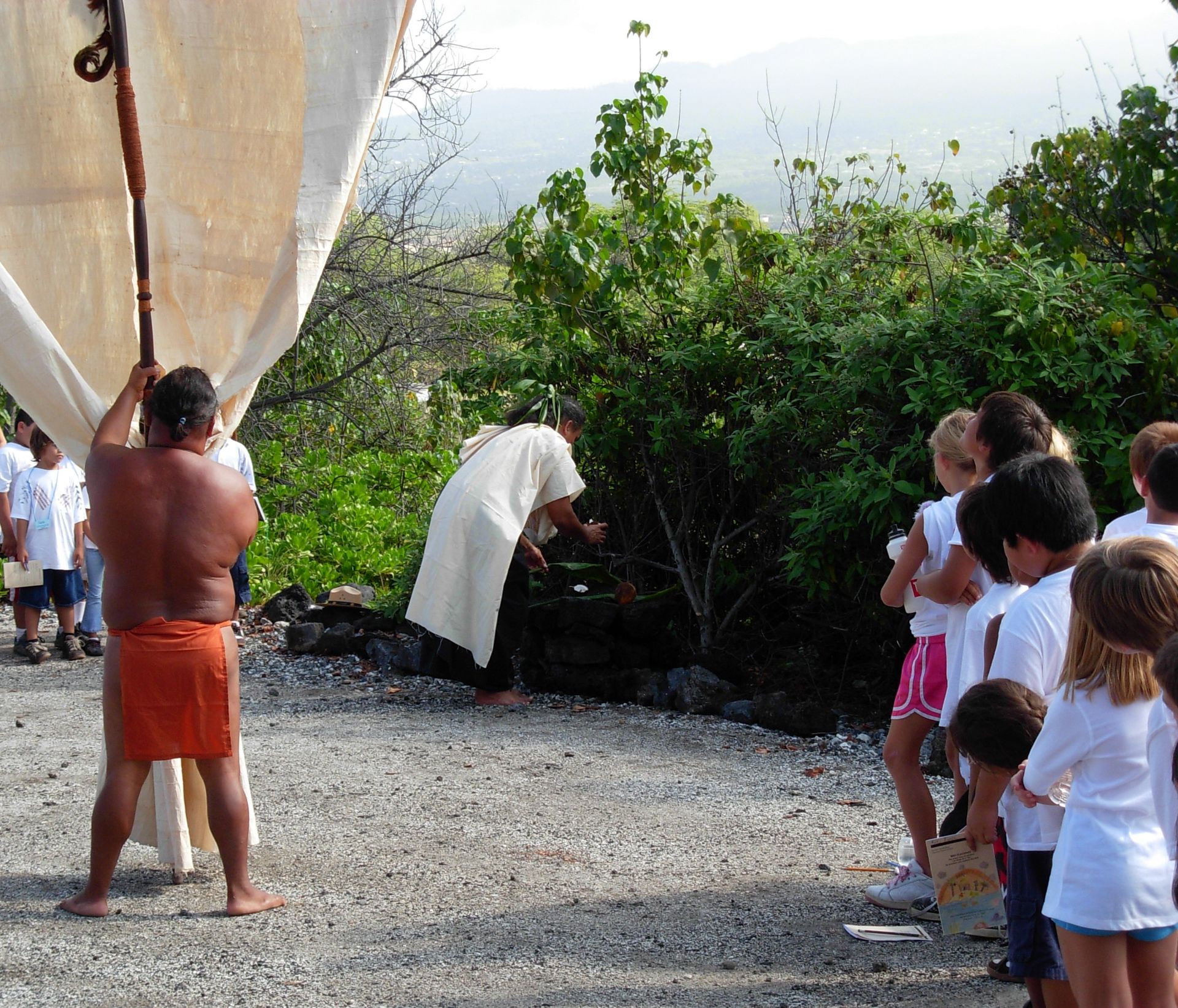 Children watch a cultural demonstration at a Hawaiian cultural festival